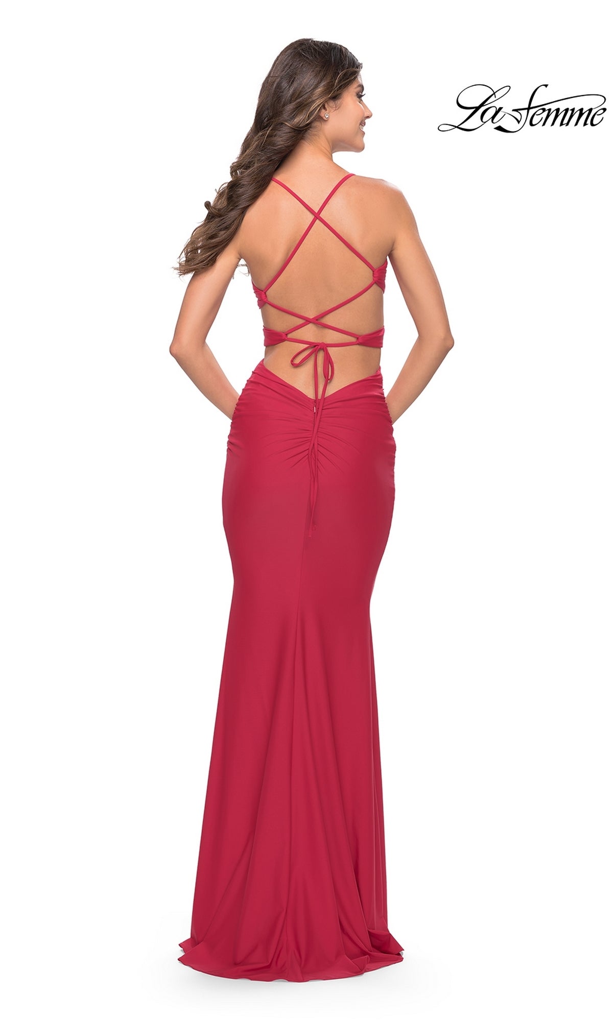 A woman in a floor-length, sleeveless red Cut-Out-Sides Long Prom Dress (La Femme 31523) featuring an open back with elegant crisscross strap details.